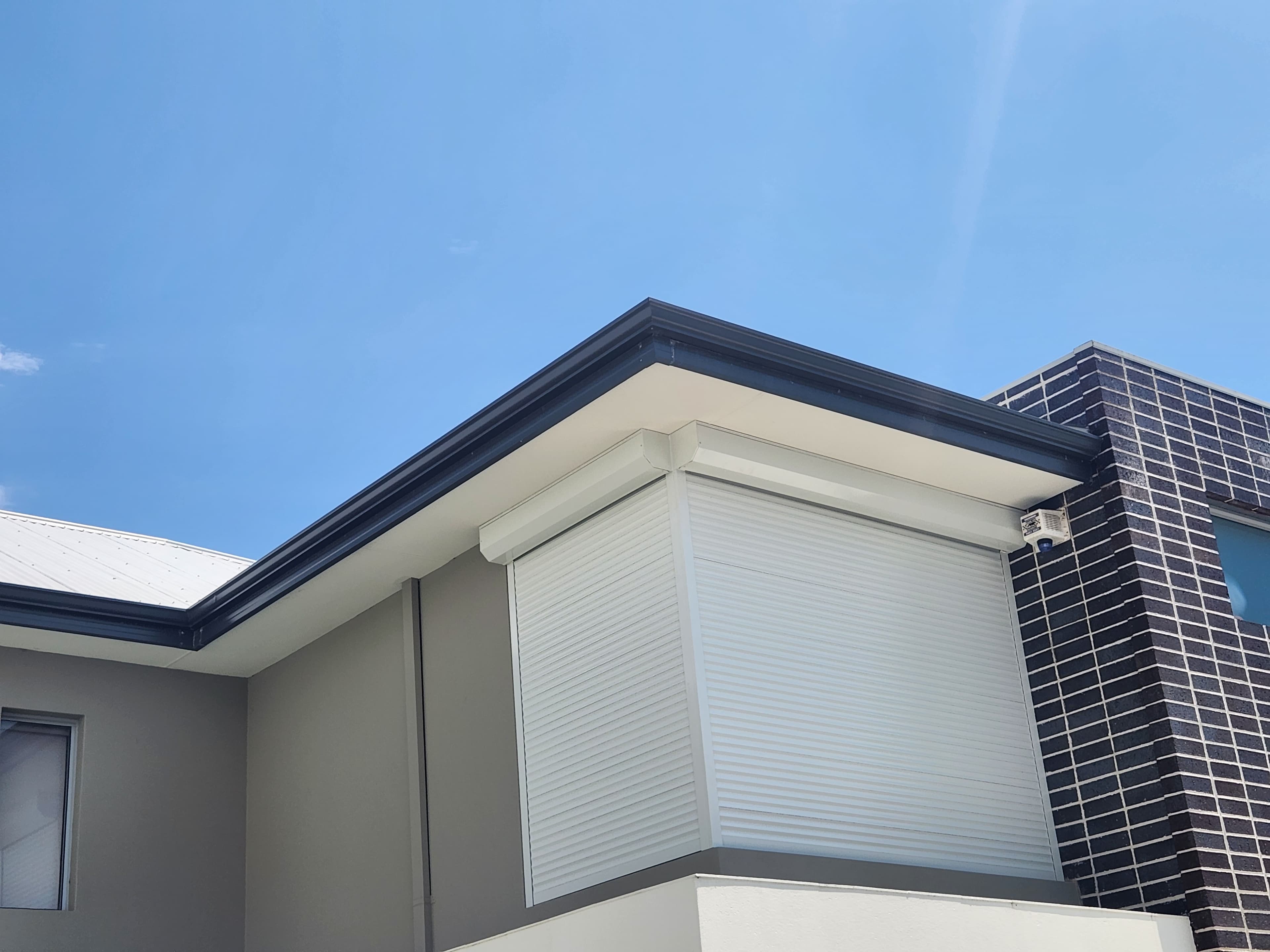 White roller shutters on corner windows of two-storey Perth home